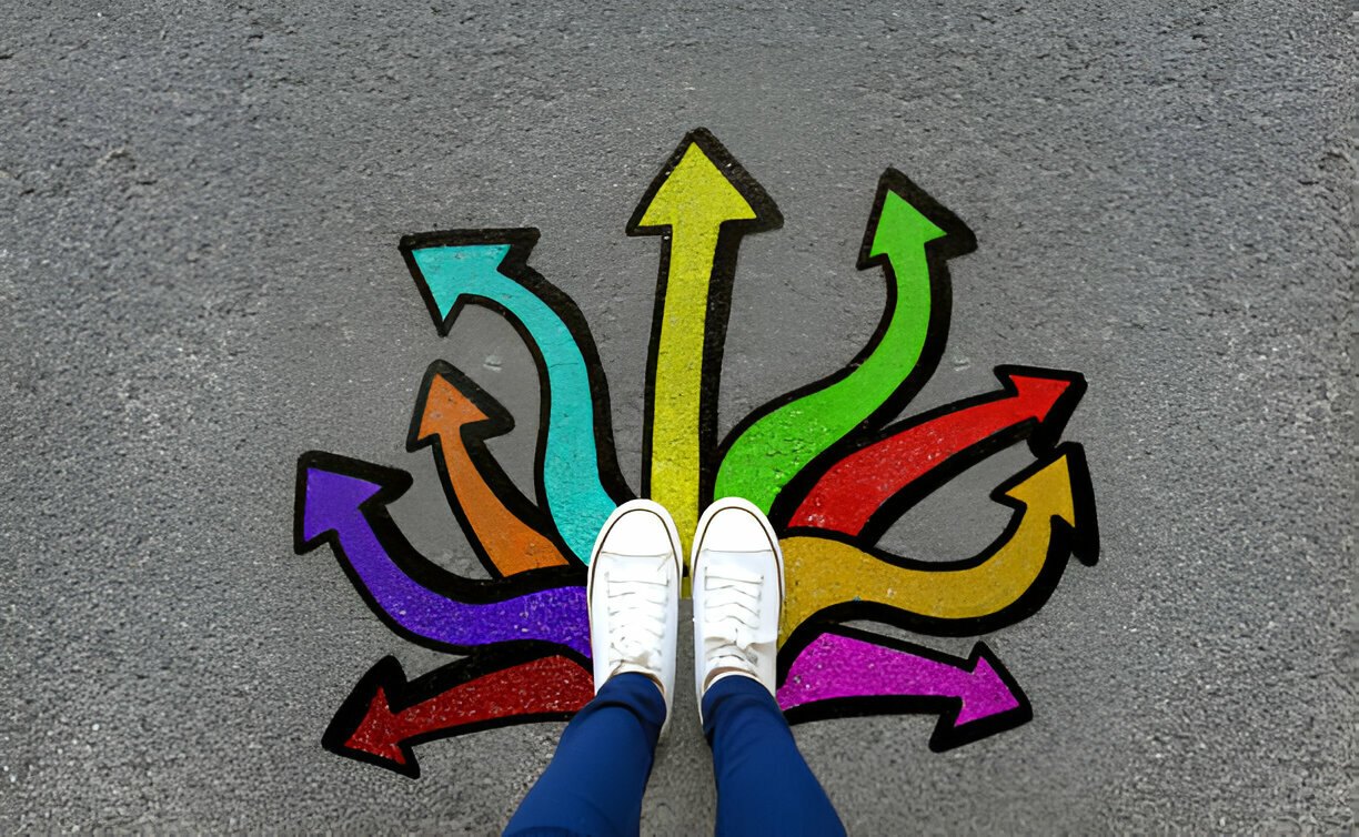 Pair of foot standing on tarmac road with colorful graffiti arrow sign choices